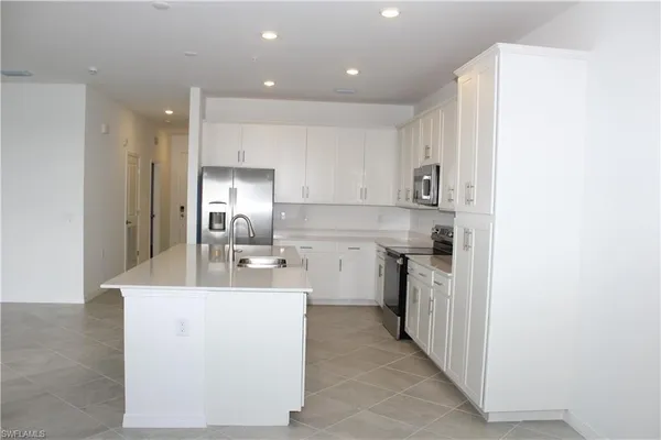 a kitchen with kitchen island sink stove and refrigerator
