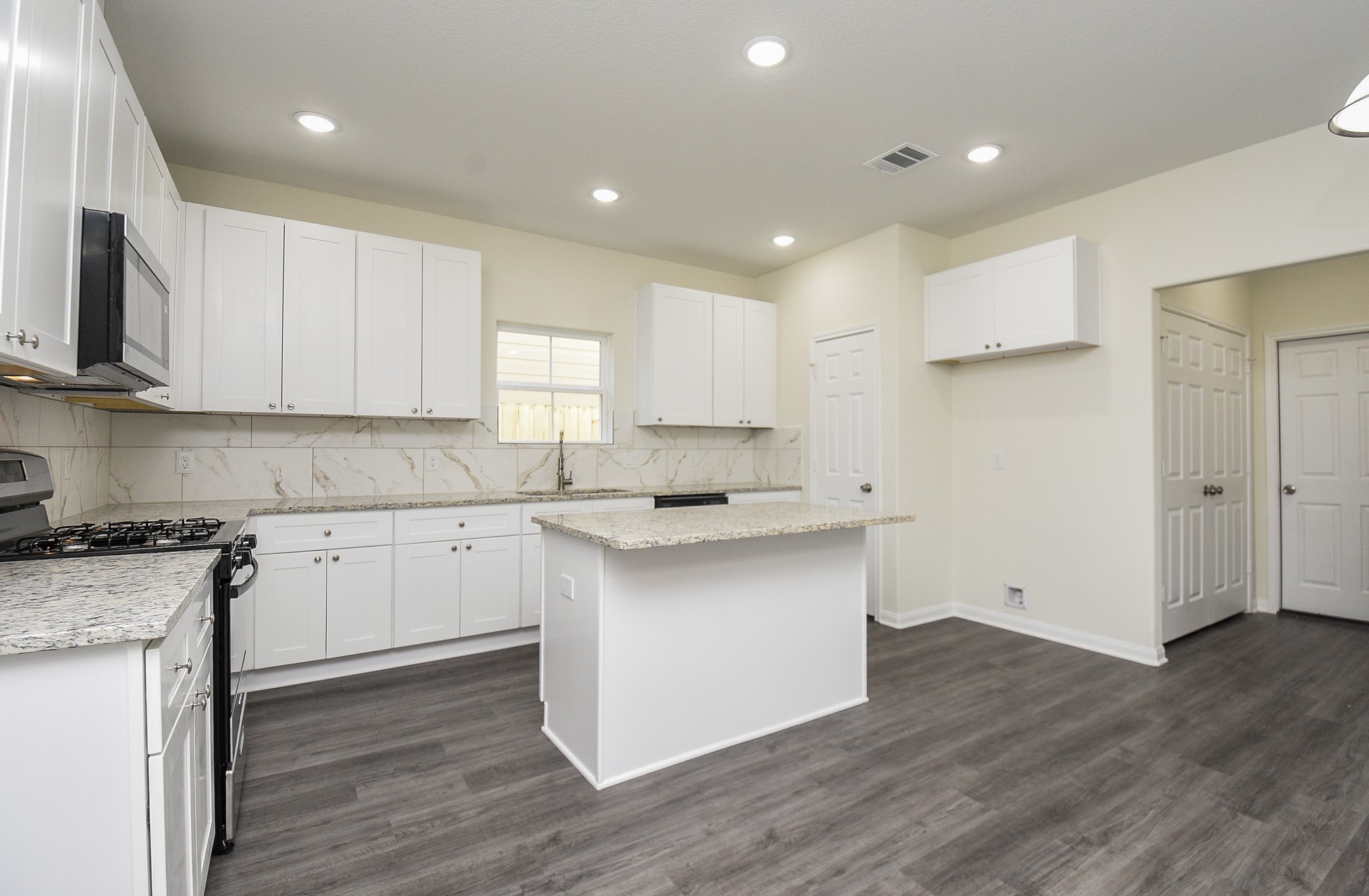 2811 Topiary Lane Houston, TX 77014 - Photo 12 of 32 a kitchen with a sink white cabinets and white appliances