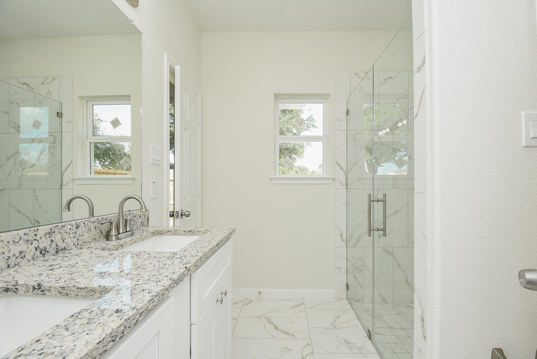 2811 Topiary Lane Houston, TX 77014 - Photo 20 of 32 a bathroom with a granite countertop sink a mirror and a shower
