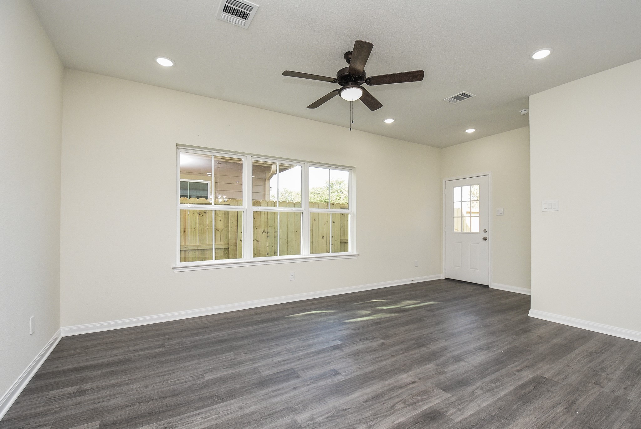 2811 Topiary Lane Houston, TX 77014 - Photo 7 of 32 a view of an empty room with wooden floor and a window