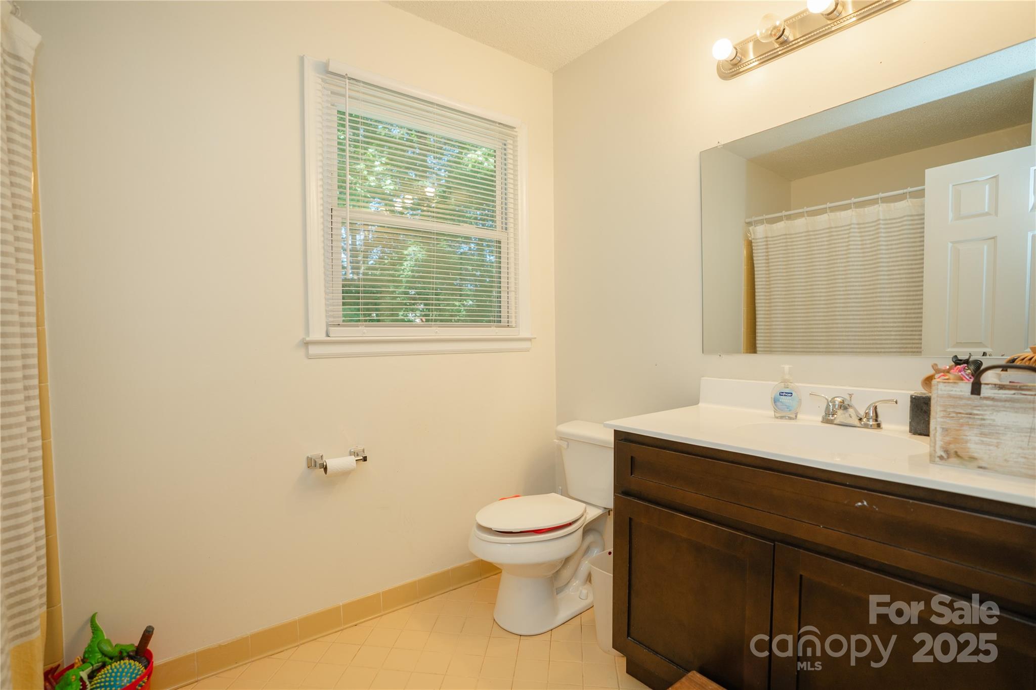 427 Willow Road Salisbury, NC 28147 - Photo 23 of 32 a bathroom with a granite countertop toilet a sink and a mirror