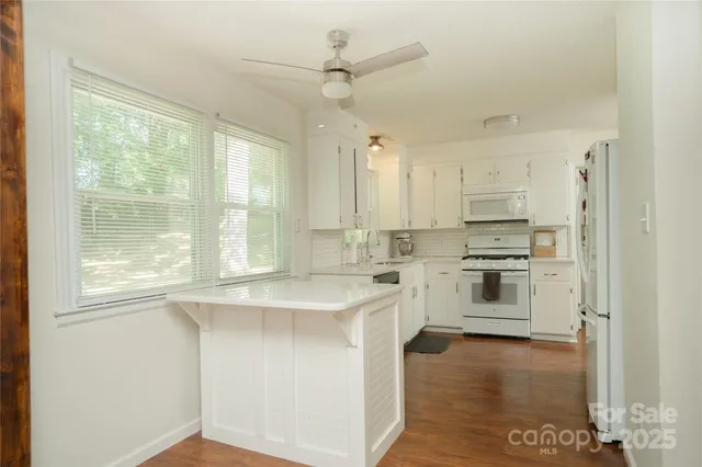 a kitchen with white cabinets and white appliances