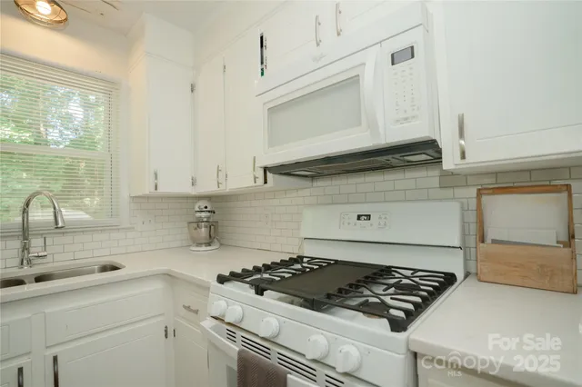 a kitchen with white cabinets and appliances