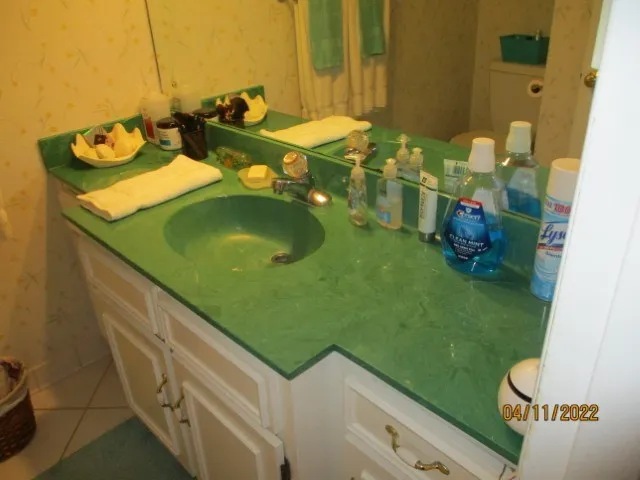 a bathroom with a granite countertop sink a mirror and vanity