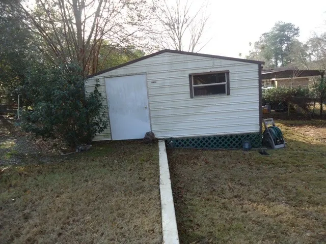 a view of a house with backyard and trees