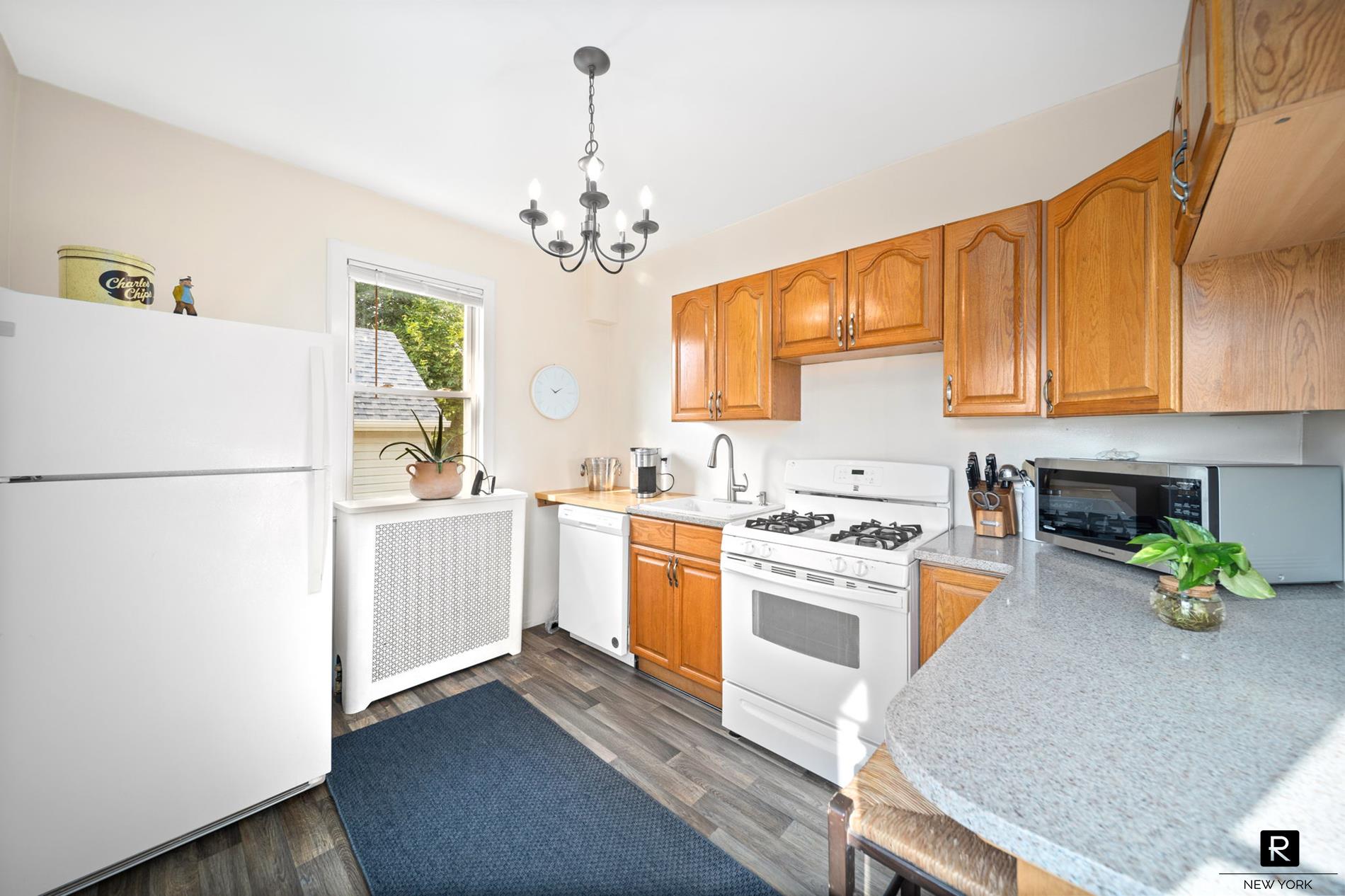111 Rochelle Street Bronx, NY 10464 - Photo 17 of 28 a kitchen with stainless steel appliances granite countertop a refrigerator a stove a sink dishwasher and white cabinets with wooden floor