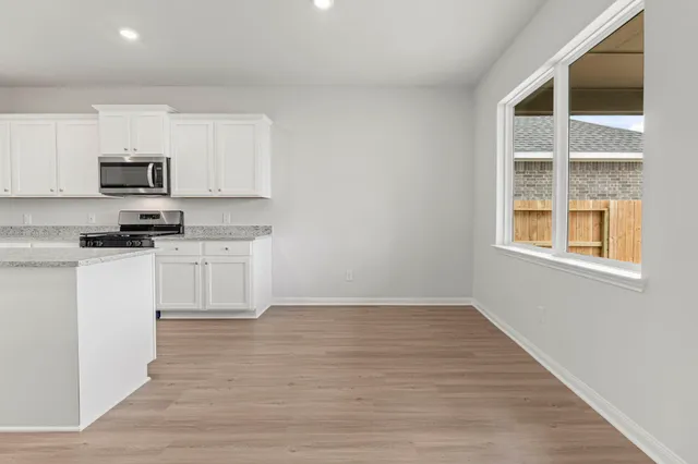 a kitchen with stainless steel appliances granite countertop a stove a sink and a microwave