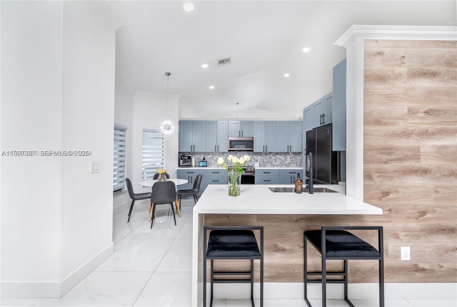 9701 Southwest 56th Terrace Miami, FL 33173 - Photo 19 of 48 a large kitchen with dining table and chairs