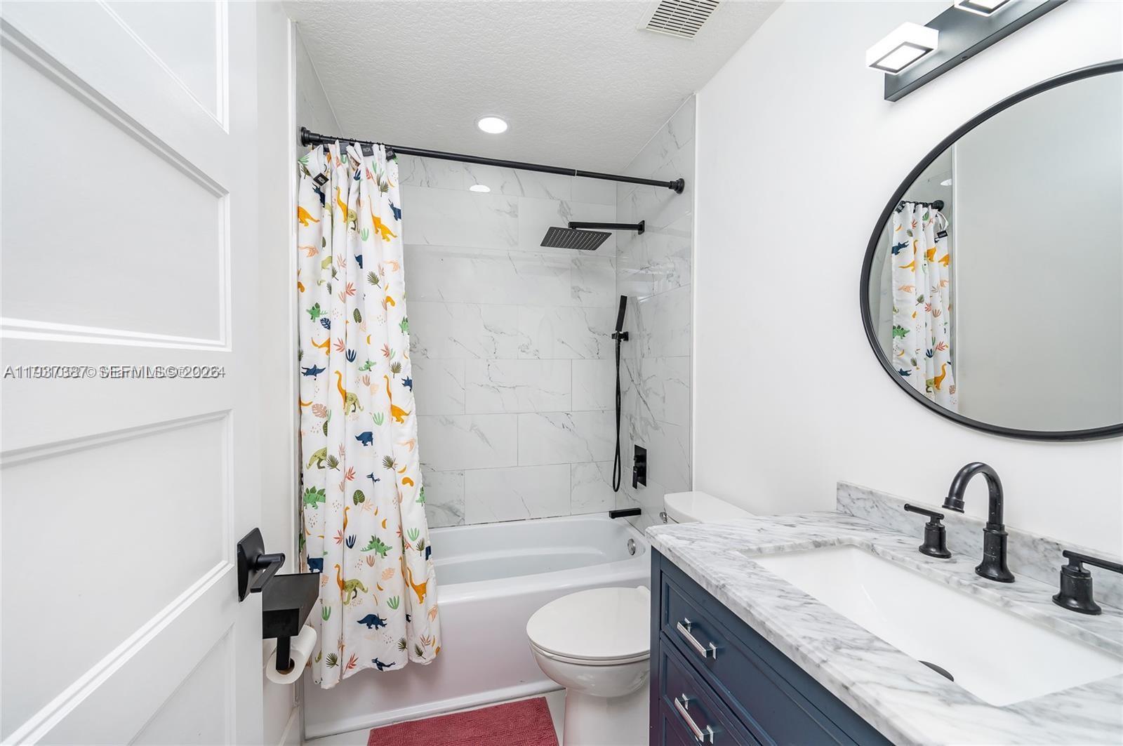 9701 Southwest 56th Terrace Miami, FL 33173 - Photo 25 of 48 a bathroom with a granite countertop sink mirror toilet and shower
