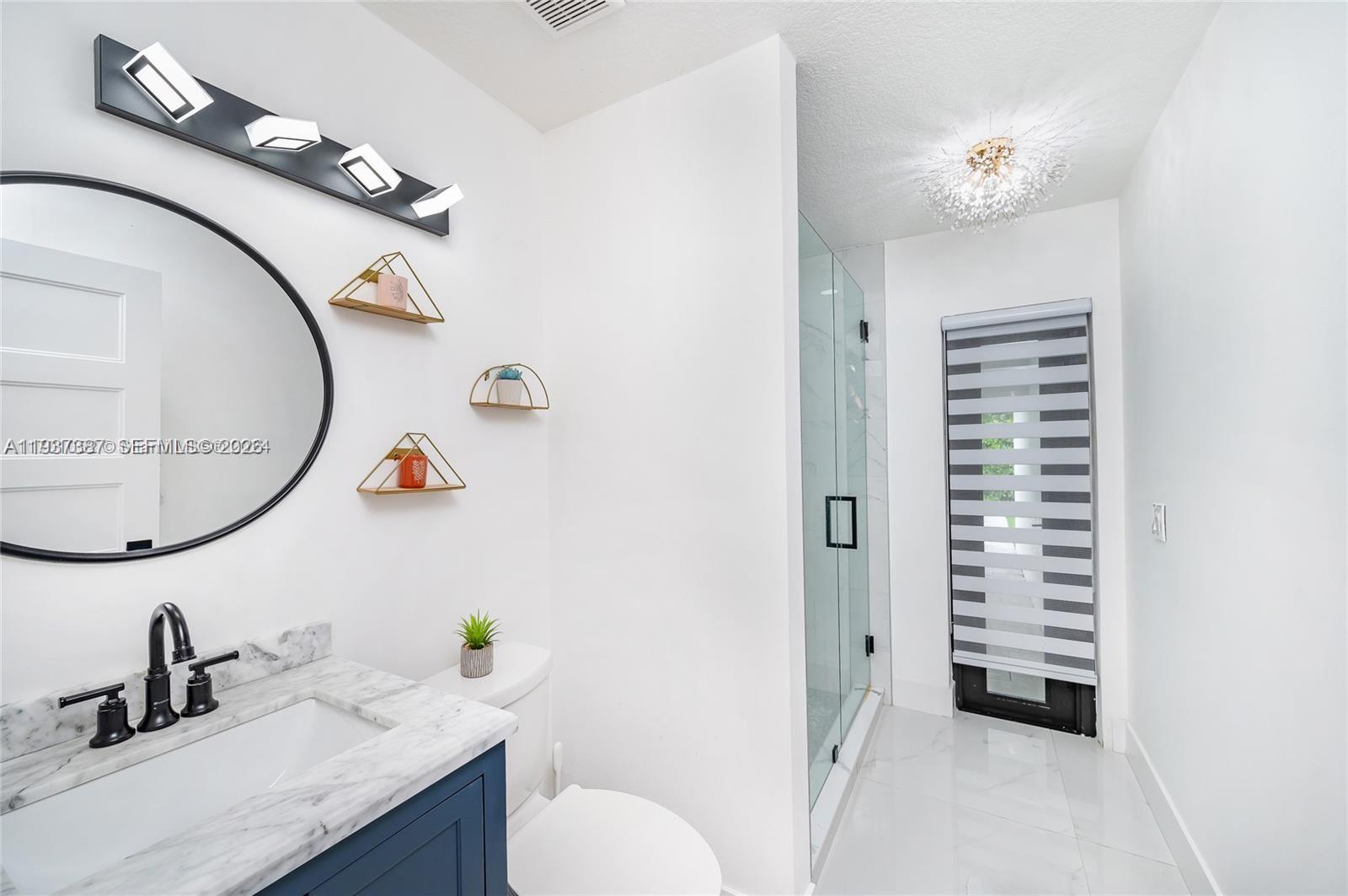 9701 Southwest 56th Terrace Miami, FL 33173 - Photo 27 of 48 a bathroom with a sink a toilet and a mirror