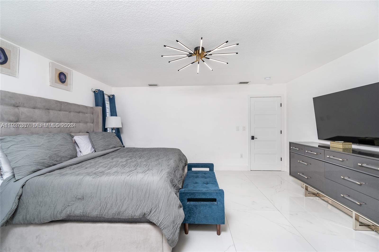 9701 Southwest 56th Terrace Miami, FL 33173 - Photo 31 of 48 a bedroom with a bed and a flat screen tv