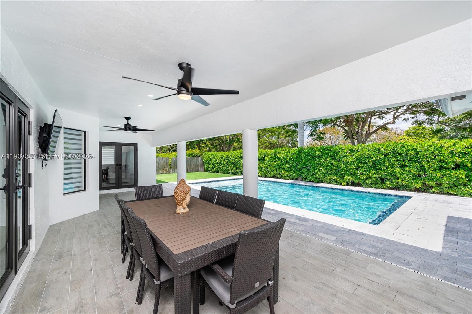 9701 Southwest 56th Terrace Miami, FL 33173 - Photo 47 of 48 a view of a patio with a table chairs and a backyard