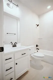a bathroom with a sink a toilet and mirror