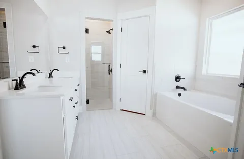 a bathroom with a tub a sink and a mirror