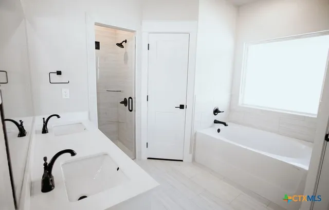 a bathroom with a tub a sink and a shower