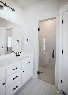 a bathroom with a shower sink and mirror