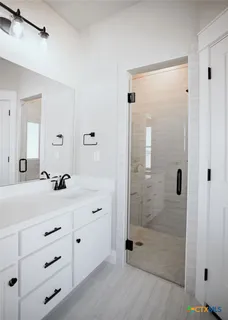 a bathroom with a shower sink and mirror