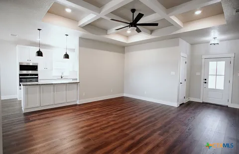 a view of a kitchen with wooden floor and a ceiling fan