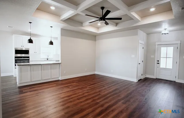 a view of a kitchen with wooden floor and a ceiling fan