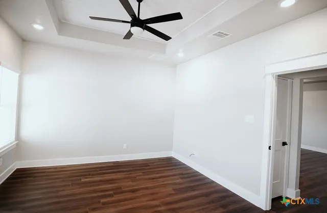 a view of a room with wooden floor and white walls