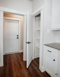 a view of wooden floor and closet in a kitchen