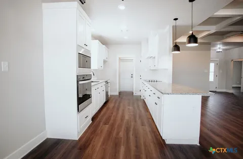 a view of a kitchen with a sink and wooden floor