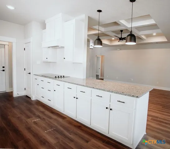 a kitchen with granite countertop white cabinets and white appliances