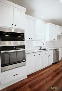 a kitchen with appliances cabinets and a wooden floor