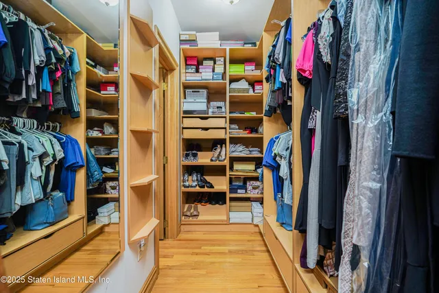 a view of walk in closet with clothes and shoes
