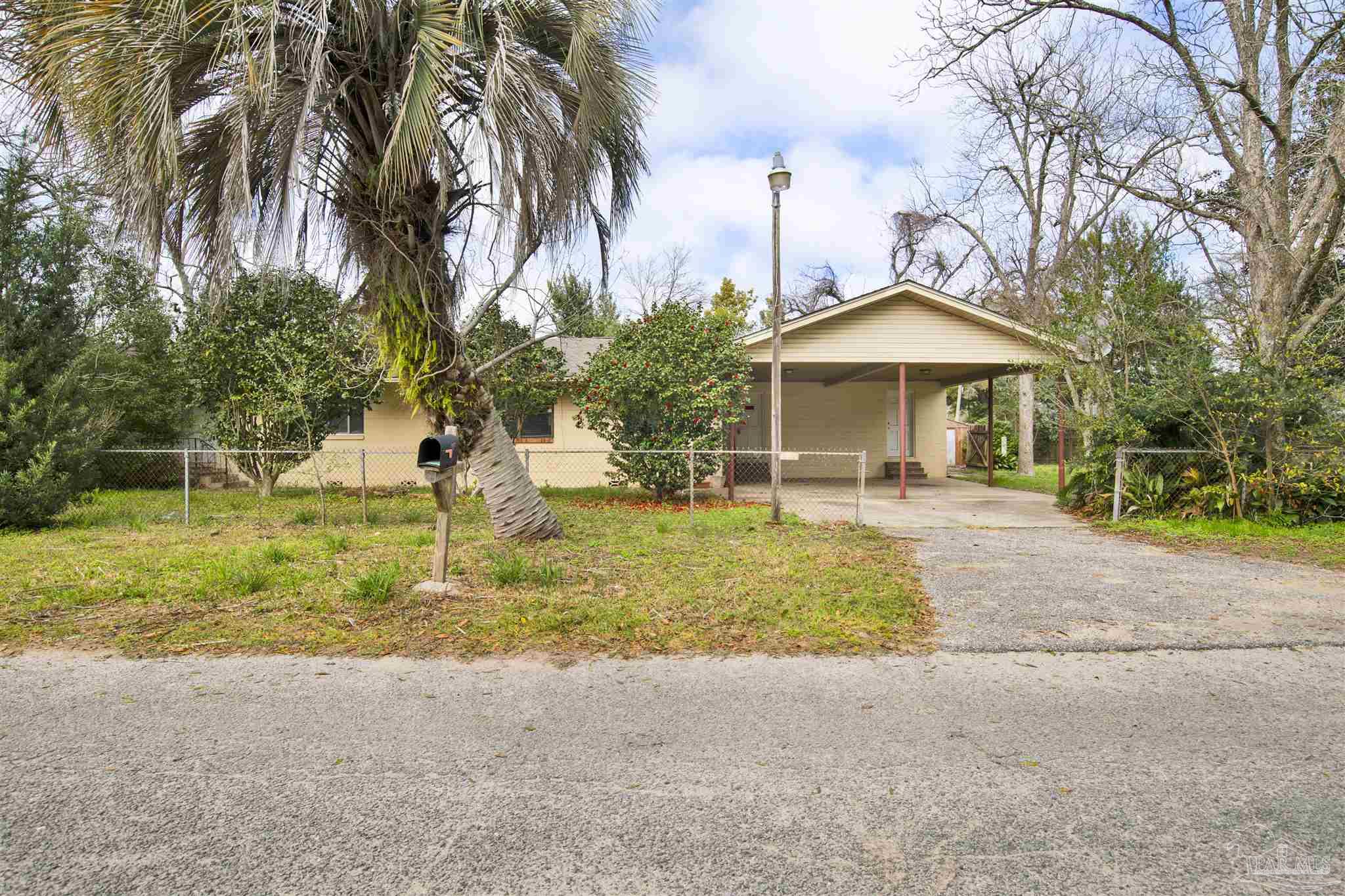2802 West Gonzalez Street Pensacola, FL 32505 - Photo 1 of 24 a front view of a house with a yard and palm trees