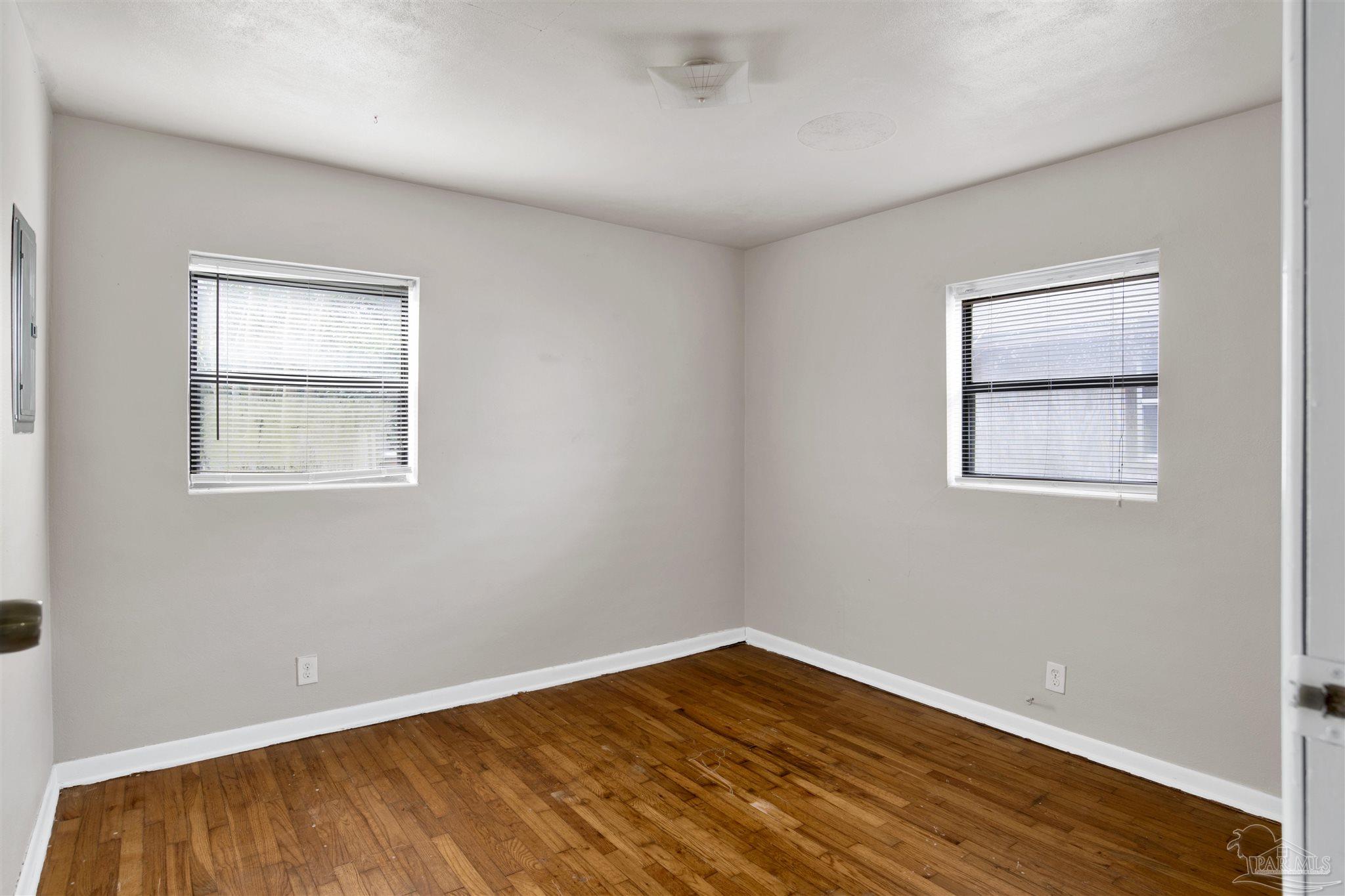 2802 West Gonzalez Street Pensacola, FL 32505 - Photo 17 of 24 a view of an empty room with wooden floor and a window