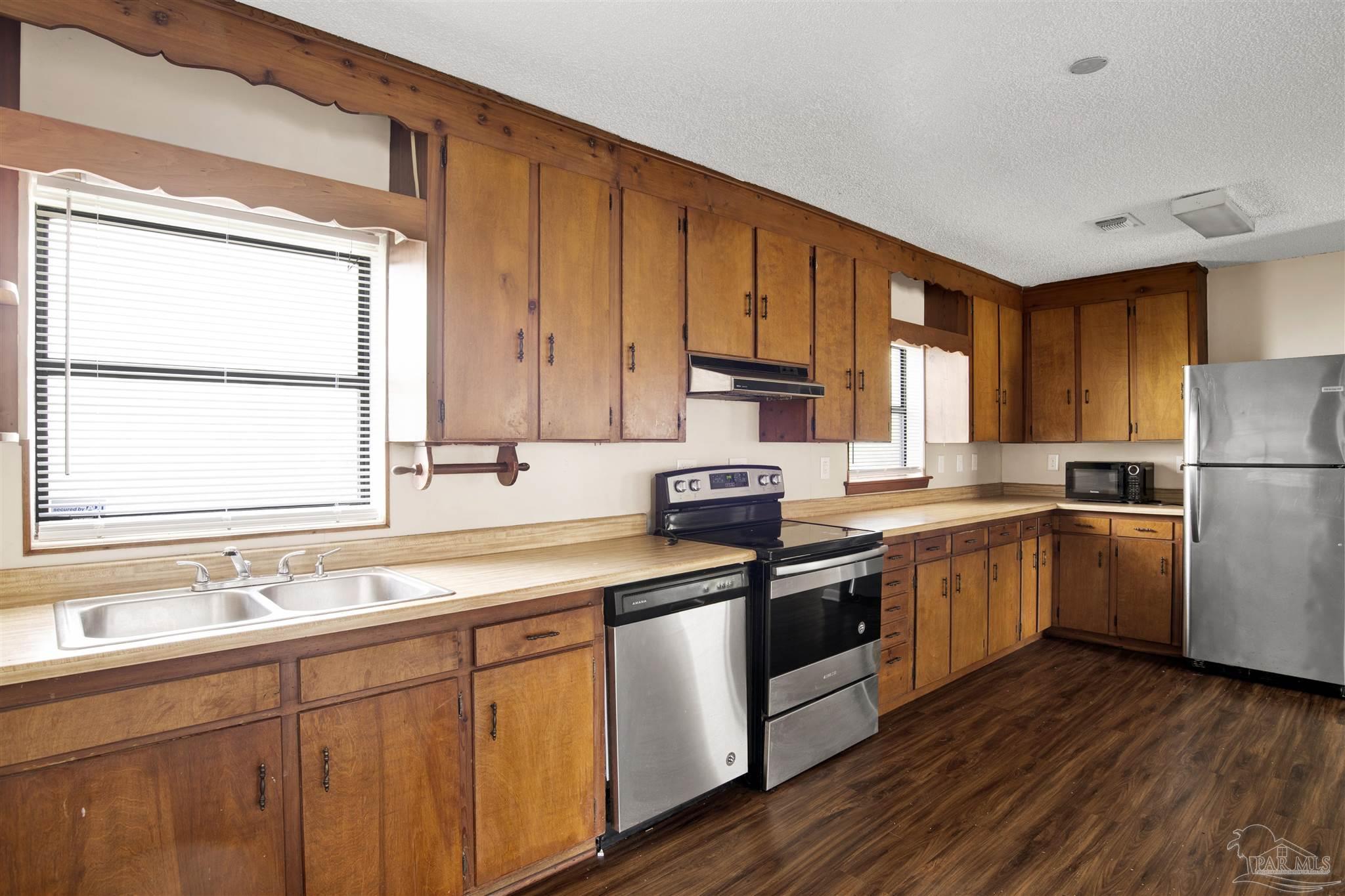 2802 West Gonzalez Street Pensacola, FL 32505 - Photo 7 of 24 a kitchen with a sink cabinets stainless steel appliances and window