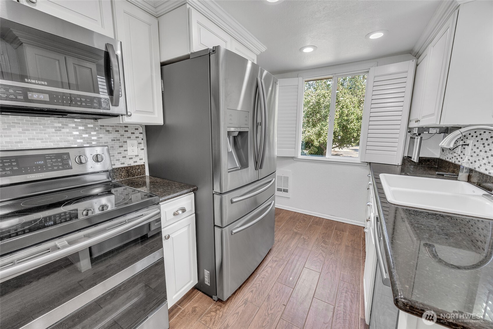 7914 242nd Street Southwest Edmonds, WA 98026 - Photo 7 of 38 a kitchen with granite countertop a refrigerator stove and microwave