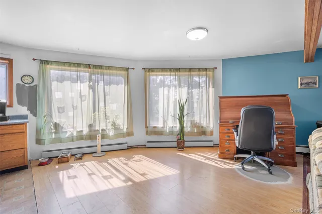 a view of a workspace with furniture and a window