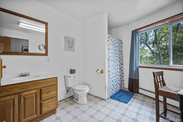 a view of bathroom with a toilet a sink and a mirror