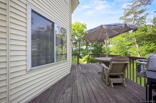 a view of a deck with wooden chairs and a yard