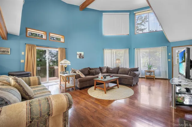 a living room with furniture wooden floor and a large window