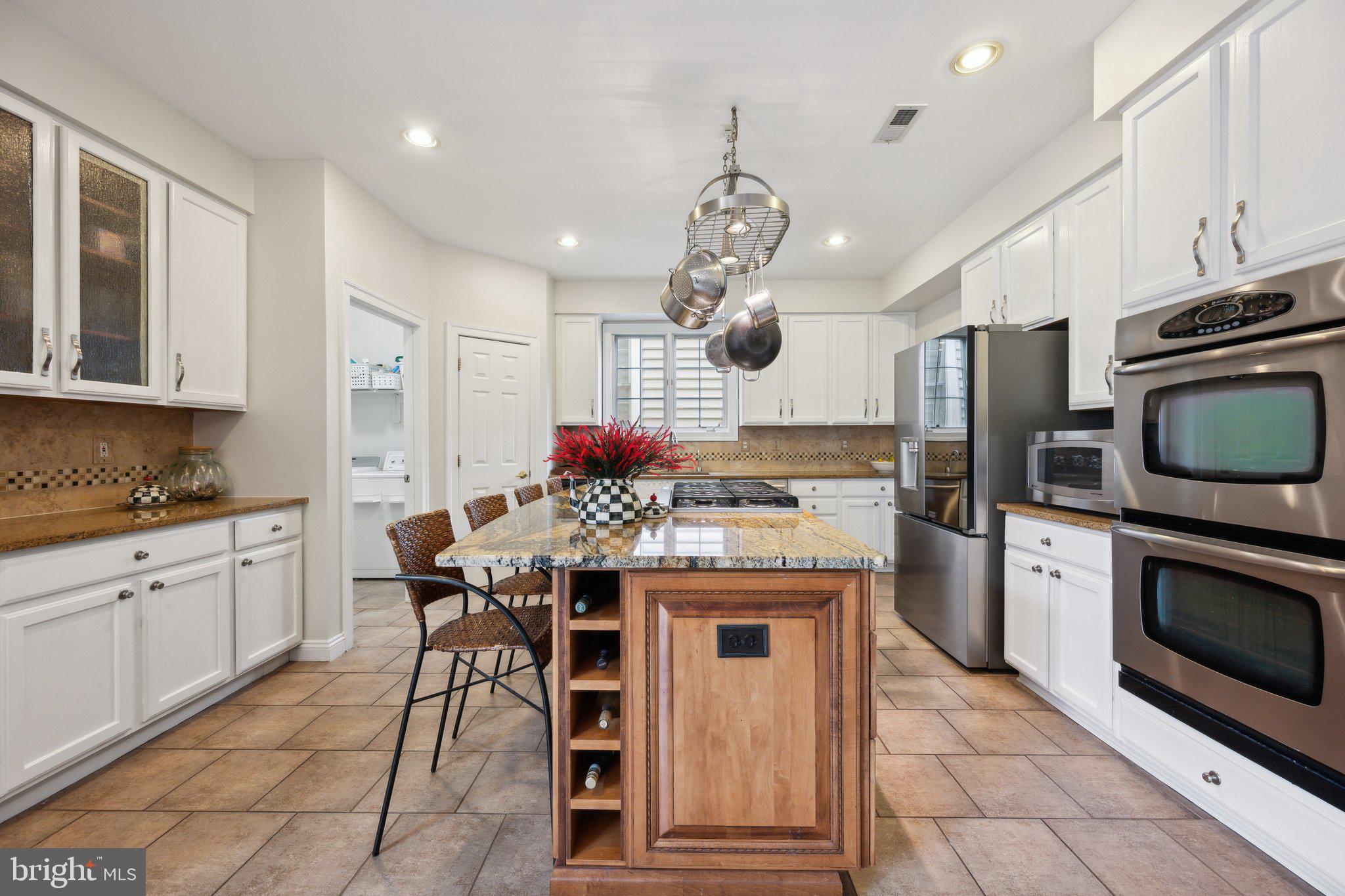 304 Thompson Dairy Way Rockville, MD 20850 - Photo 13 of 42 a kitchen with stainless steel appliances granite countertop a stove top oven a sink dishwasher a dining table and chairs with wooden floor