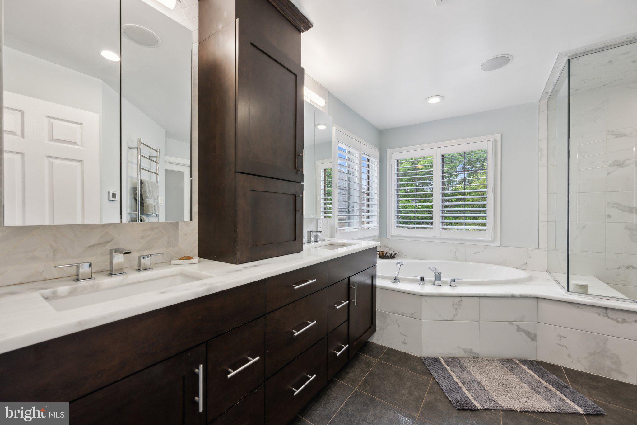 304 Thompson Dairy Way Rockville, MD 20850 - Photo 19 of 42 a bathroom with a double vanity sink large mirror and a bathtub