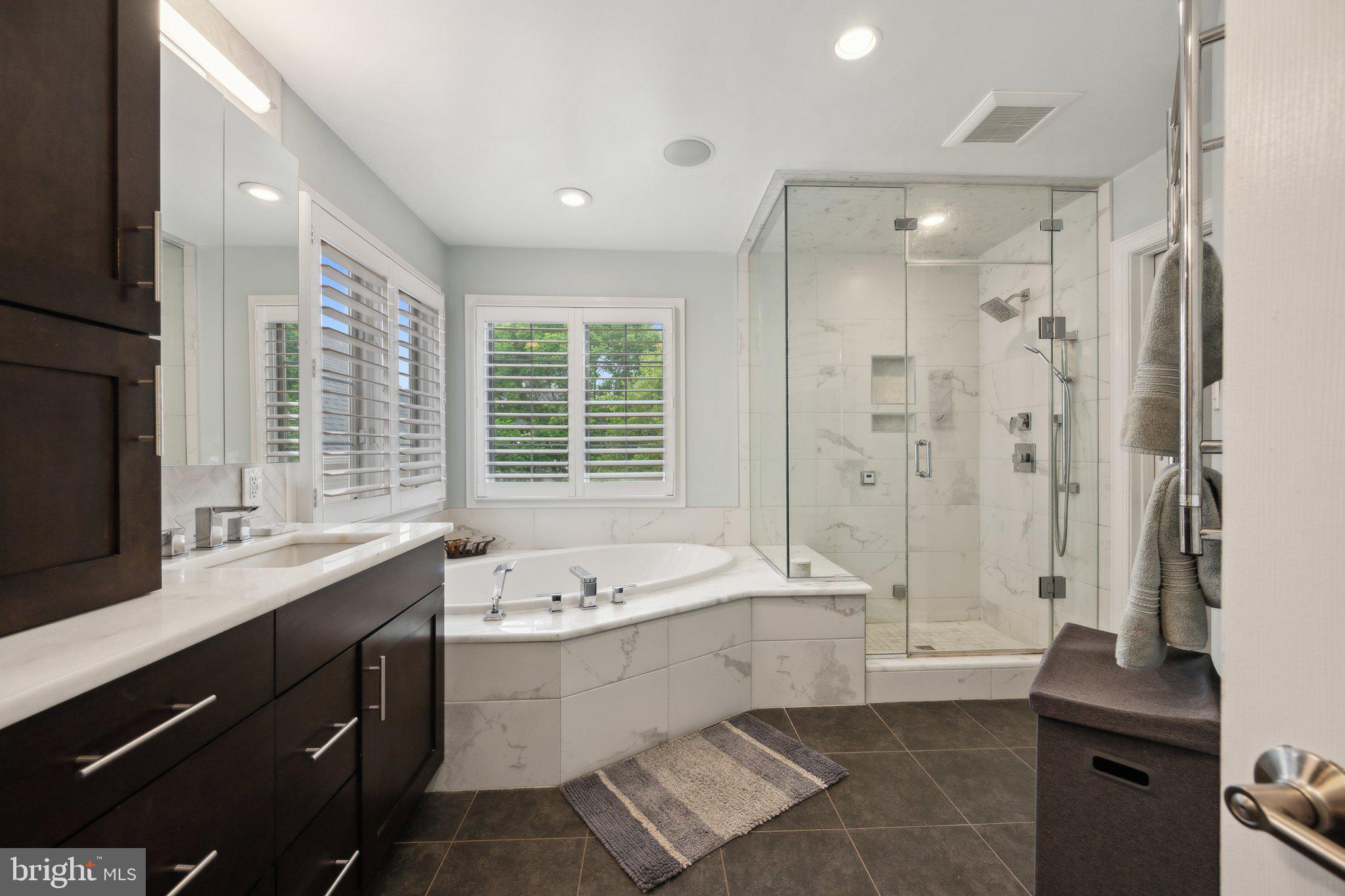 304 Thompson Dairy Way Rockville, MD 20850 - Photo 20 of 42 a bathroom with a double vanity sink a large mirror and a bathtub