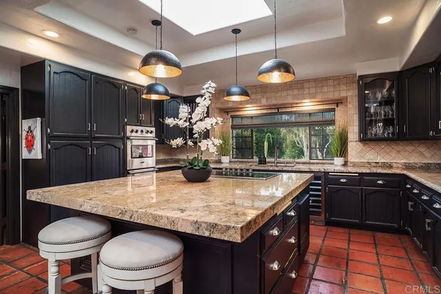 a kitchen with stainless steel appliances granite countertop a sink a stove and a wooden cabinets