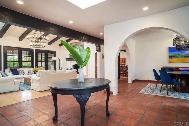 a living room with furniture a rug potted plant and a large window