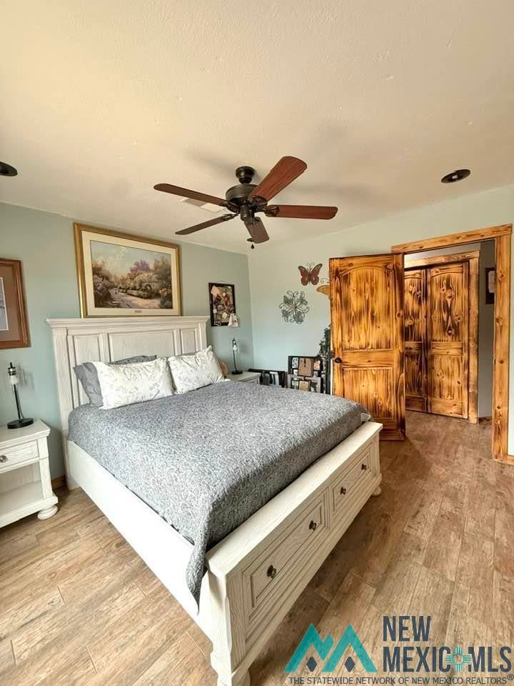 5404 Sioux Road Carlsbad, NM 88220 - Photo 48 of 100 Spacious room featuring wood-finish flooring, a ceiling fan with light, and distressed wood-panel double doors