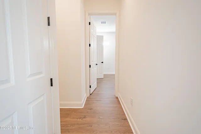 an empty room with a windows and a ceiling fan
