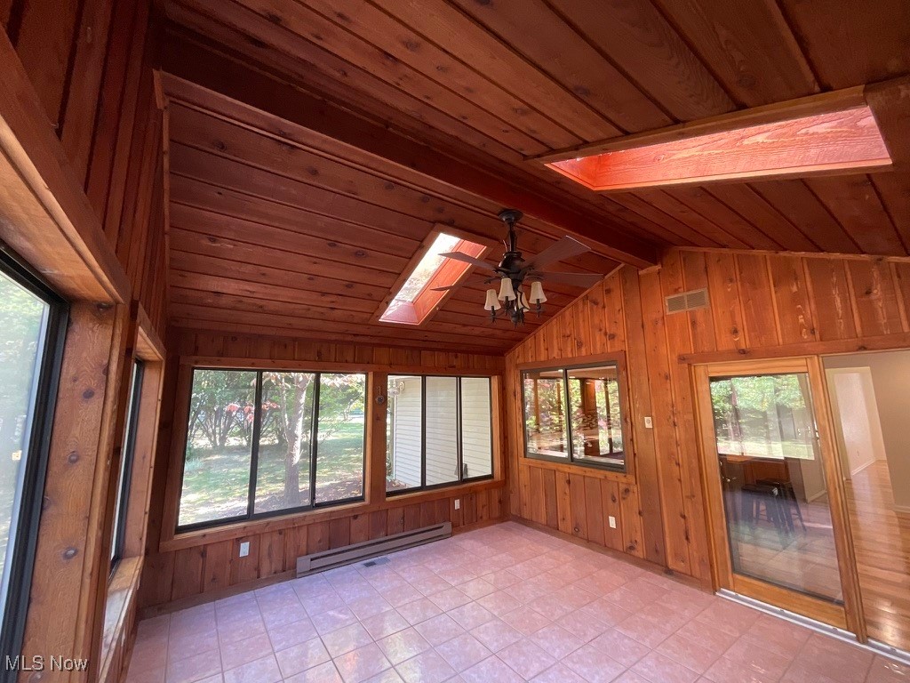 11331 Palmer Road Painesville, OH 44077 - Photo 34 of 47 Unfurnished sunroom featuring vaulted ceiling with skylight, plenty of natural light, a baseboard heating unit, and ceiling fan