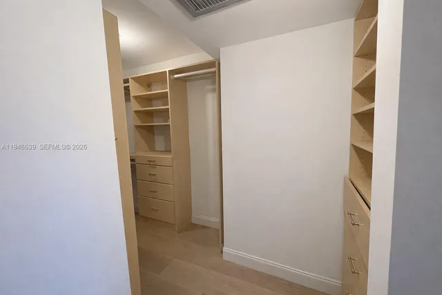 a view of walk in closet with empty racks