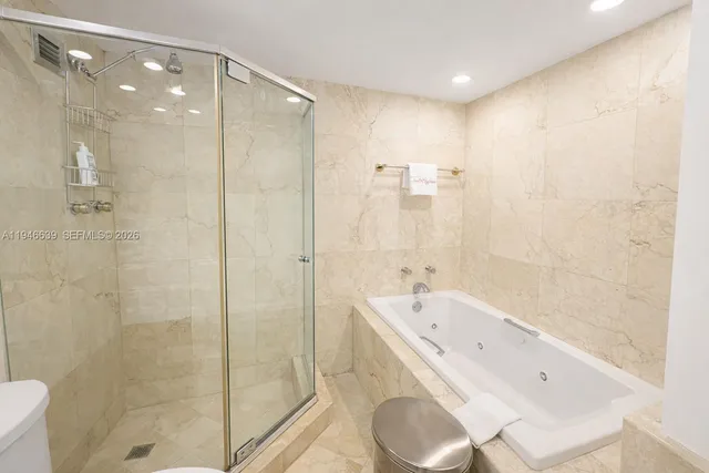 a bathroom with a bathtub shower sink vanity and a toilet