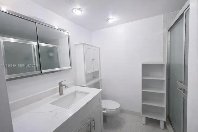 a bathroom with a sink a toilet and shower