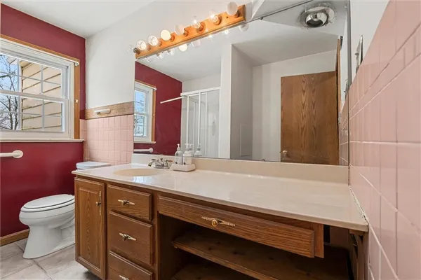 a bathroom with a sink a toilet and a mirror