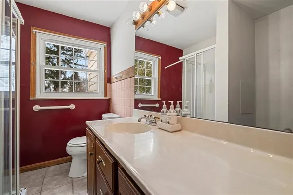 a bathroom with a granite countertop sink a large mirror and a toilet